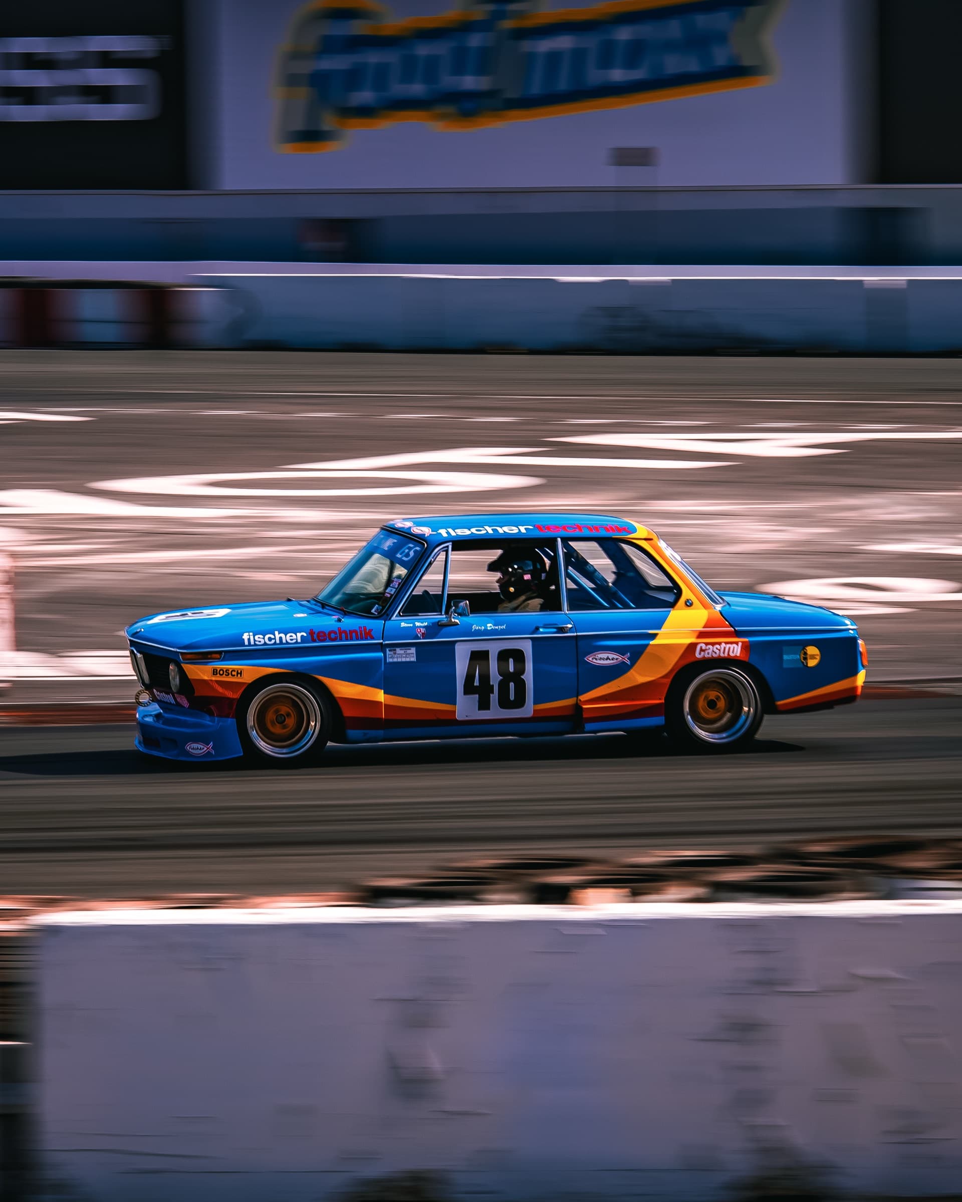 Fischer-liveried BMW 2002 race car panning on track