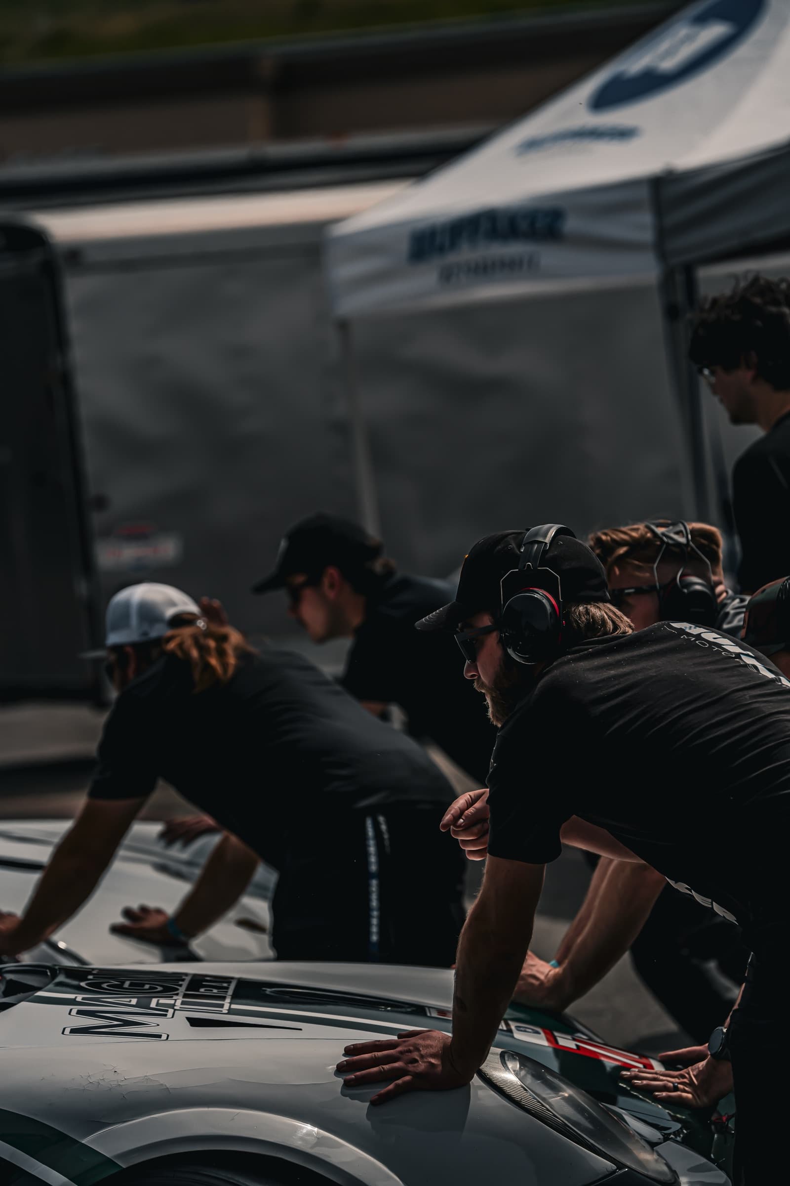Pit crew pushing a race car in the paddock